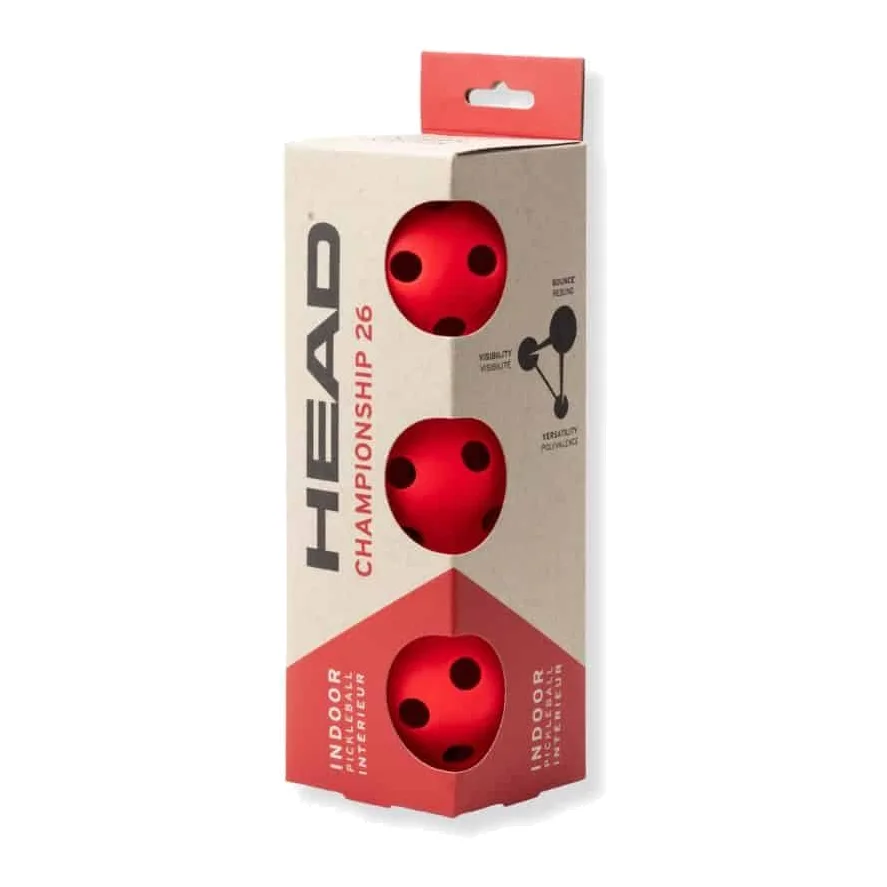 Drie rode HEAD Championship Indoor pickleball ballen liggend op een indoor pickleball veld.