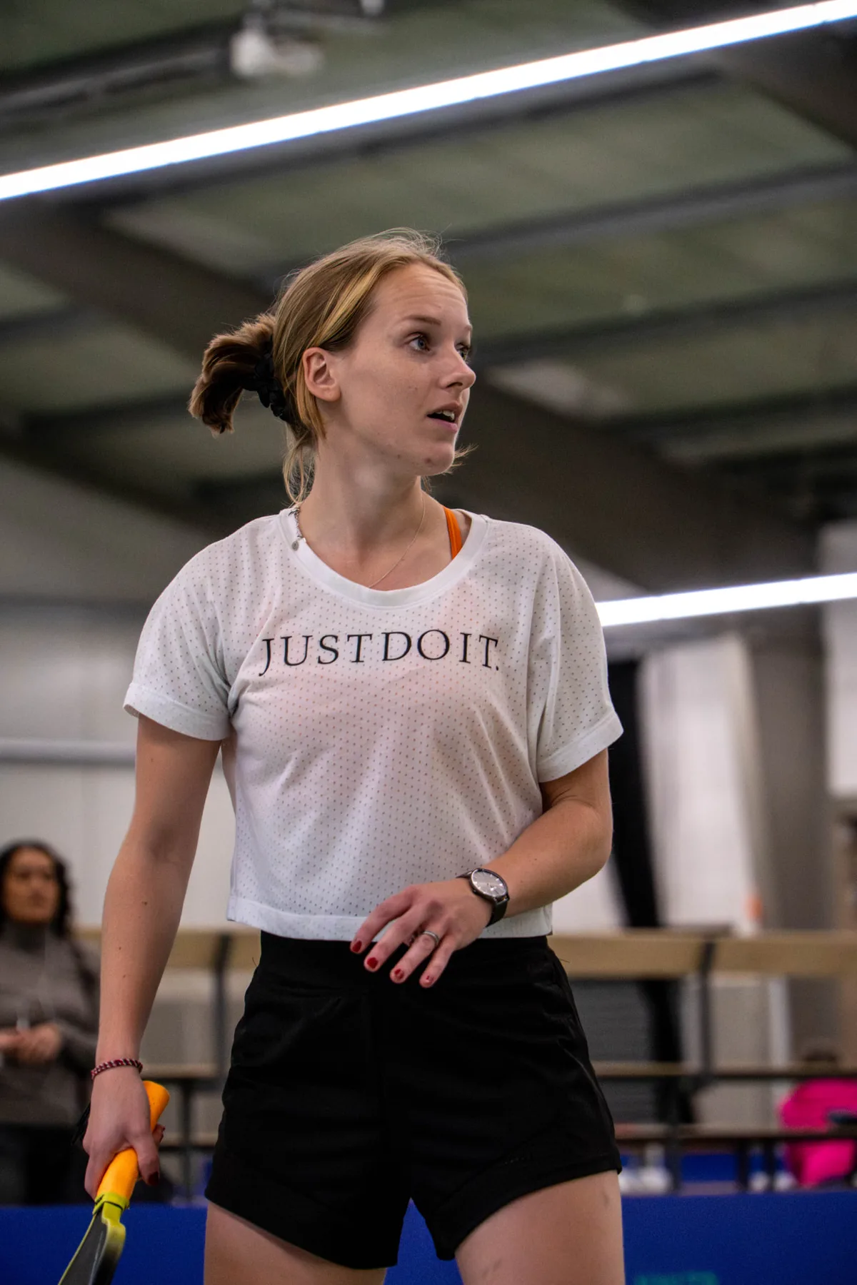 Speelster staat klaar aan het net tijdens een pickleballwedstrijd in de sporthal