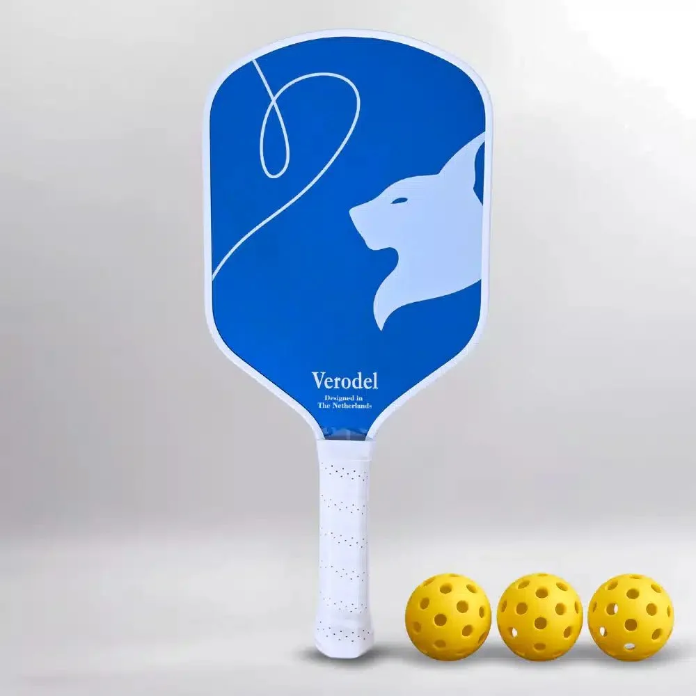 De Verodel WAVE ELITE pickleball paddle in het blauw, met een ronde vorm en carbon oppervlak, liggend op een pickleballbaan.