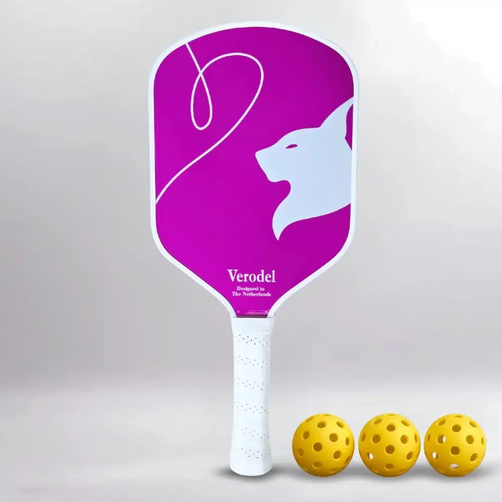 Roze Verodel BLUSH GLOW pickleball paddle met wit handvat en drie gele pickleballen ernaast.